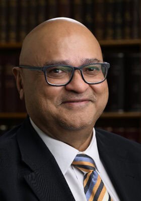 Professional lawyer from Tan And Tan Lawyers smiling in office setting.