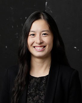 Team member smiling, professional woman in black blazer for Tan And Tan Lawyers.