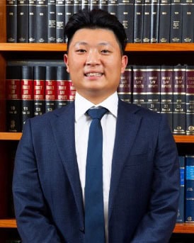 Experienced lawyer at Tan And Tan Lawyers in front of legal books.